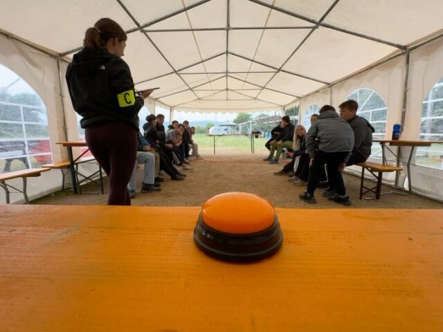 Tag 6 - Activity Quiz & Gottesdienst 💭⛪️🏕️
Mit einer guten Abwechslung aus Bewegung und schnellem Überlegen haben sich die Teilis beim Morgenprogramm „Activity Quizz“ schon einmal richtig auspowern können. Im Laufe des Tages gab es eine kleine Tanzsession um den Regen freundlich weg zu tanzen. Als Nachmittagsprogramm kam unsere Pastoralreferendarin Bärbel in Begleitung von Alexandra als Besuch zu uns auf den Zeltplatz. Gemeinsam haben alle einen wunderschönen Gottesdienst gestaltet, in den die Teilis aktiv eingebunden wurden. Als Ausgleich zu unserem aktiven und sportlichen Morgenprogramm, war der Gottesdienst ein schöner und ruhiger Ausgleich. Über den ganzen Tag hinweg wurde selbstverständlich unser Geburtstagskind Noah gefeiert. Mit Pfannkuchen zum Frühstück, Kuchen am Lagerfeuer und ganz vielen Geburtstagsständchen wurde der Tag zu einem ganz besonderen. Als feierlichen Abschluss des Tages gab es noch unsere legendäre Kloparty. 🏕️🌦️🎂🎶

Klingt das spannend und nach dem perfekten Tag im Sommer für dich? Dann melde dich noch heute für unser Sommerzeltlager 2027 an und werde Teil 10 ereignisreicher und unvergesslicher Tage. Wir freuen uns auf dich!
Jetzt anmelden unter: https://www.fkjazeltlager.de/anmeldung/

#fkja #sommerzeltlager #geburtstag #zeltlagerfürkinder #katholischekirche